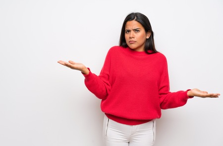 Young Colombian girl with red sweater unhappy for not understand somethingの写真素材