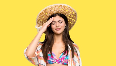 Teenager girl on summer vacation has just realized something and has intending the solution over isolated yellow backgroundの写真素材