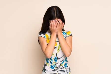 Teenager girl with floral dress with tired and sick expressionの写真素材