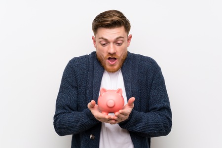 Redhead man holding a piggybankの写真素材
