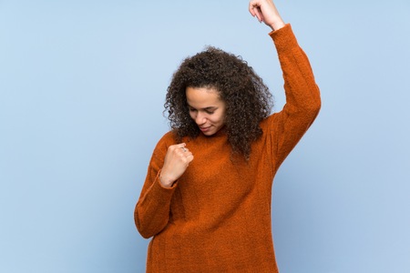Dominican woman with curly hair celebrating a victoryの写真素材