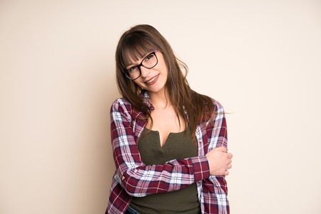 Young woman on ocher background laughingの写真素材