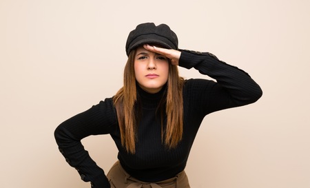 Fashion woman with hat looking far away with hand to look somethingの写真素材