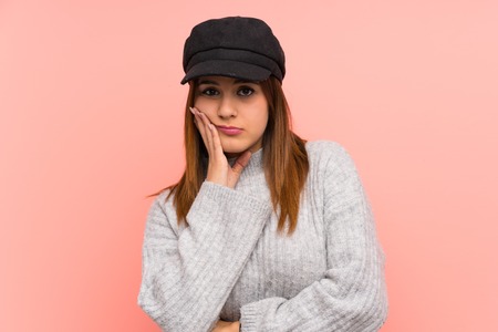 Fashion woman with hat over pink wall unhappy and frustratedの写真素材