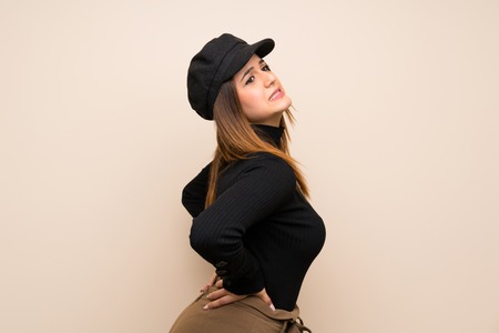 Fashion woman with hat suffering from backache for having made an effortの写真素材