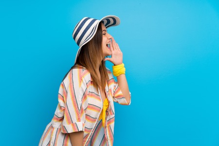 Young woman in bikini in summer holidays shouting with mouth wide open to the lateralの写真素材