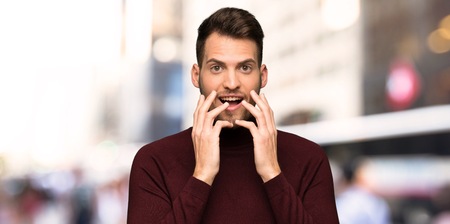 Man with turtleneck sweater with surprise facial expression in the cityの写真素材