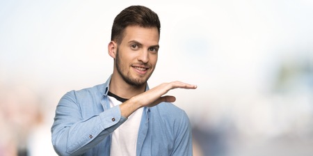 Handsome man holding copyspace to insert an ad at outdoorsの写真素材