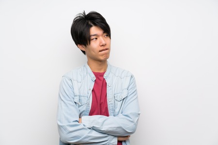 Asian man on isolated white background with confuse face expressionの写真素材