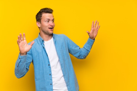 Blonde handsome man over isolated wall with surprise facial expressionの写真素材