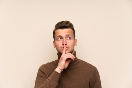 Blonde handsome man over isolated wall doing silence gestureの写真素材