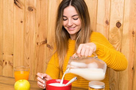 Young woman having breakfast in a kitchenの写真素材