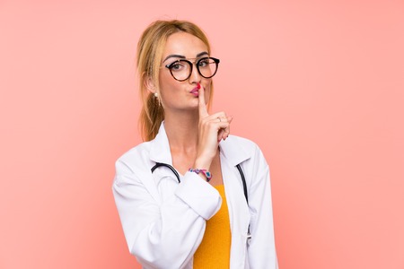 Young blonde doctor woman doing silence gestureの写真素材