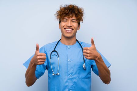 Surgeon doctor african american man giving a thumbs up gestureの写真素材