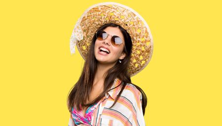 Teenager girl on summer vacation with glasses and happy over isolated yellow background