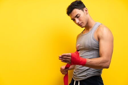 Handsome sport man over isolated background in boxing bandagesの写真素材