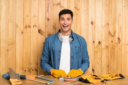 Craftsmen man over wood background with surprise facial expressionの写真素材
