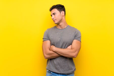 Handsome man over isolated yellow wall portraitの写真素材