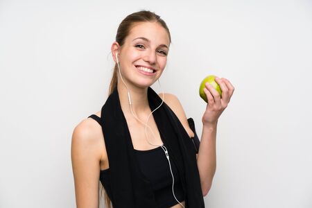 Young sport woman over isolated white background with an appleの写真素材