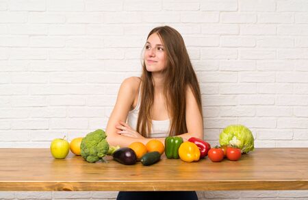 Young woman with many vegetables standing and looking to the sideの写真素材