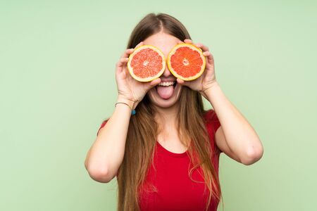Young woman with long hair wearing grapefruit slices as glassesの写真素材