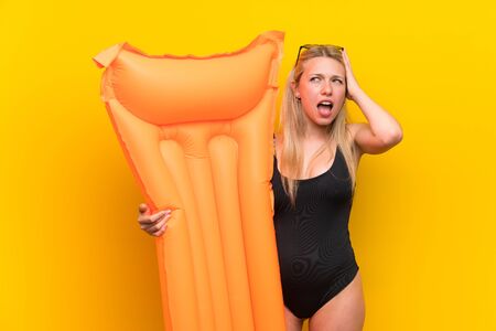Young woman in swimsuit over yellow background unhappy and frustrated with something. Negative facial expressionの写真素材