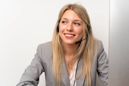 Young woman working with headset in a officeの写真素材