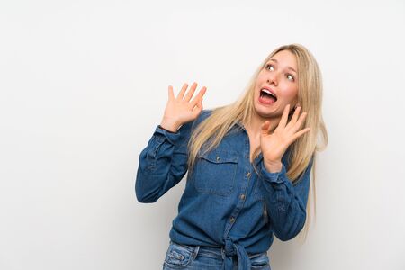 Young blonde woman over isolated white wall nervous and scaredの写真素材