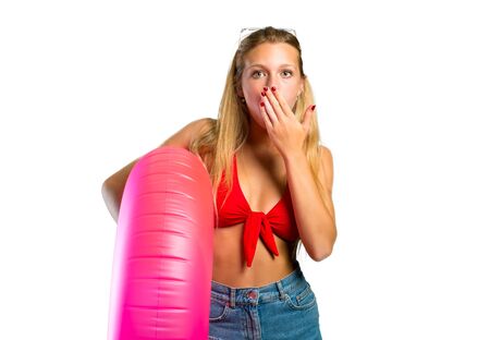 Blonde woman in summer vacation making surprise gesture on isolated white backgroundの写真素材
