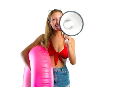 Blonde woman in summer vacation holding a megaphone on isolated white backgroundの写真素材
