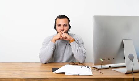 Telemarketer Colombian man showing a sign of silence gestureの写真素材