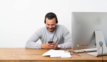 Telemarketer Colombian man sending a message with the mobile