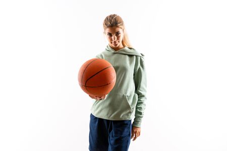 Teenager girl playing basketball over isolated white backgroundの写真素材