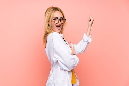 Young blonde doctor woman making strong gestureの写真素材