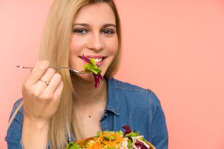 Young blonde woman with saladの写真素材