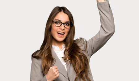 Business woman celebrating a victory over isolated grey backgroundの写真素材