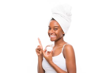 African American teenager girl with moisturizer over isolated white backgroundの写真素材