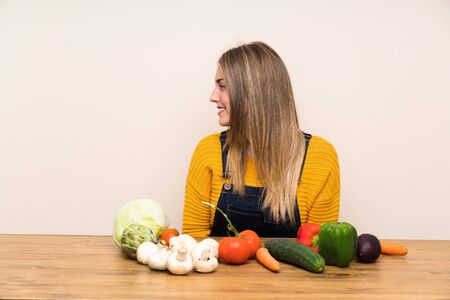 Woman with lots of vegetables standing and looking to the sideの写真素材