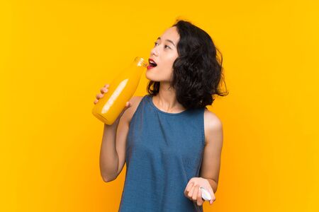Asian young woman holding an orange juiceの写真素材