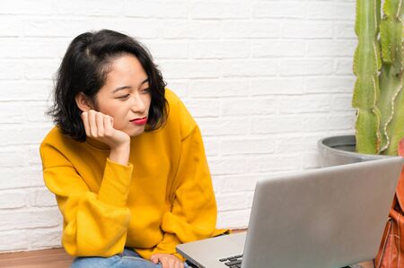 Asian young woman sitting on the floorの写真素材
