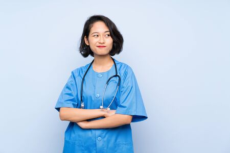 Surgeon doctor woman making doubts gesture while lifting the shouldersの写真素材