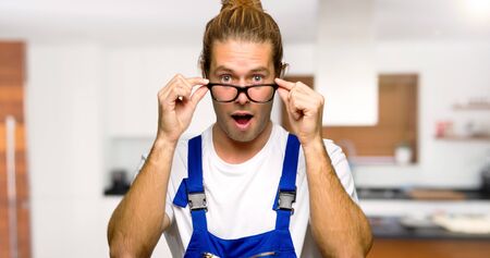 Workman with glasses and surprised in a houseの写真素材