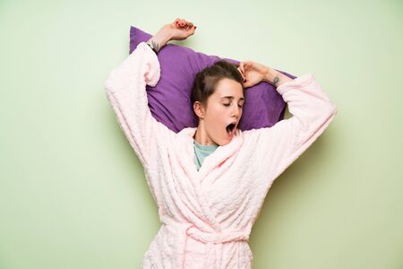 Young woman in pajama yawningの写真素材
