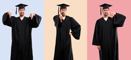 Set of Man on his graduation day University showing thumb down sign with negative expression on colorful backgroundの写真素材