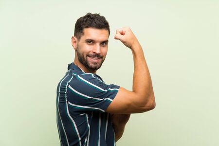 Handsome man over isolated background making strong gestureの写真素材