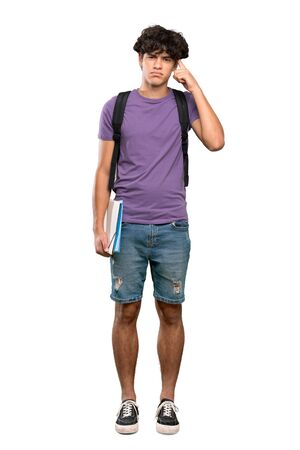 A full-length shot of a Young student man having doubts and thinking over isolated white backgroundの写真素材