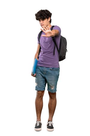 A full-length shot of a Young student man nervous stretching hands to the front over isolated white backgroundの写真素材