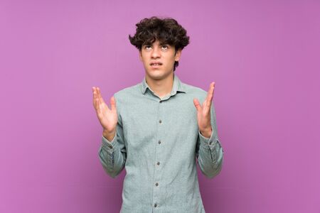 Young man over isolated purple wall frustrated by a bad situationの写真素材