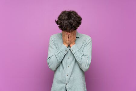 Young man over isolated purple wall with tired and sick expressionの写真素材