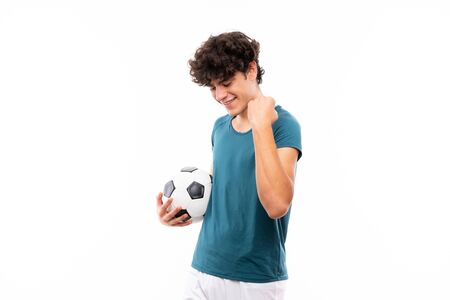 Young football player man over isolated white wall celebrating a victoryの写真素材